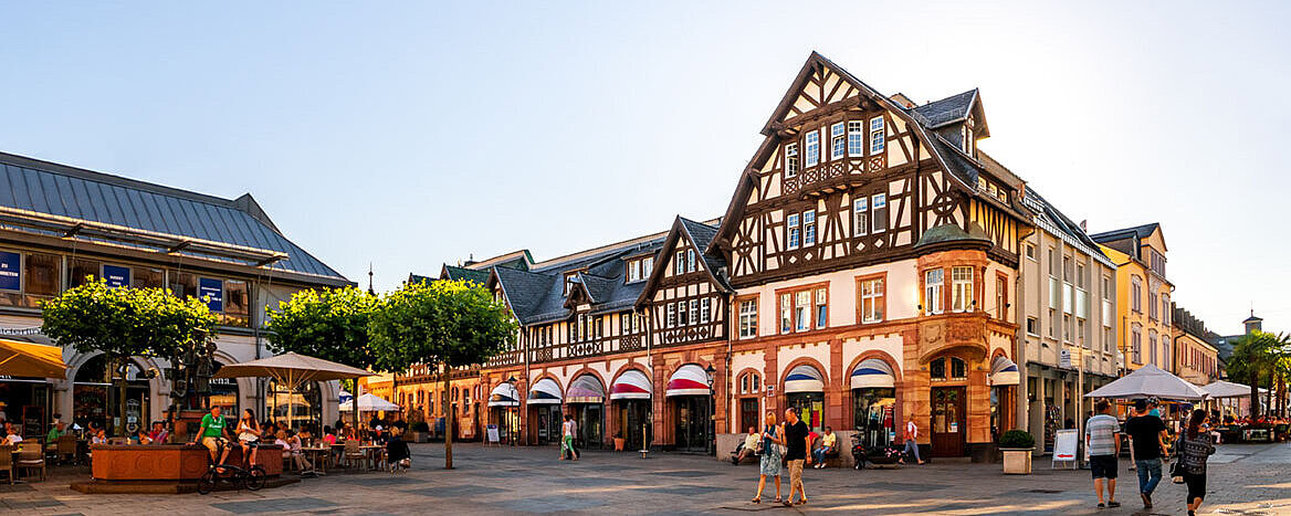 © Sina Ettmer - AdobeStock.com Belebter Marktplatz in der Altstadt von Bad Homburg mit historischen Fachwerkhäusern und Außengastronomie.