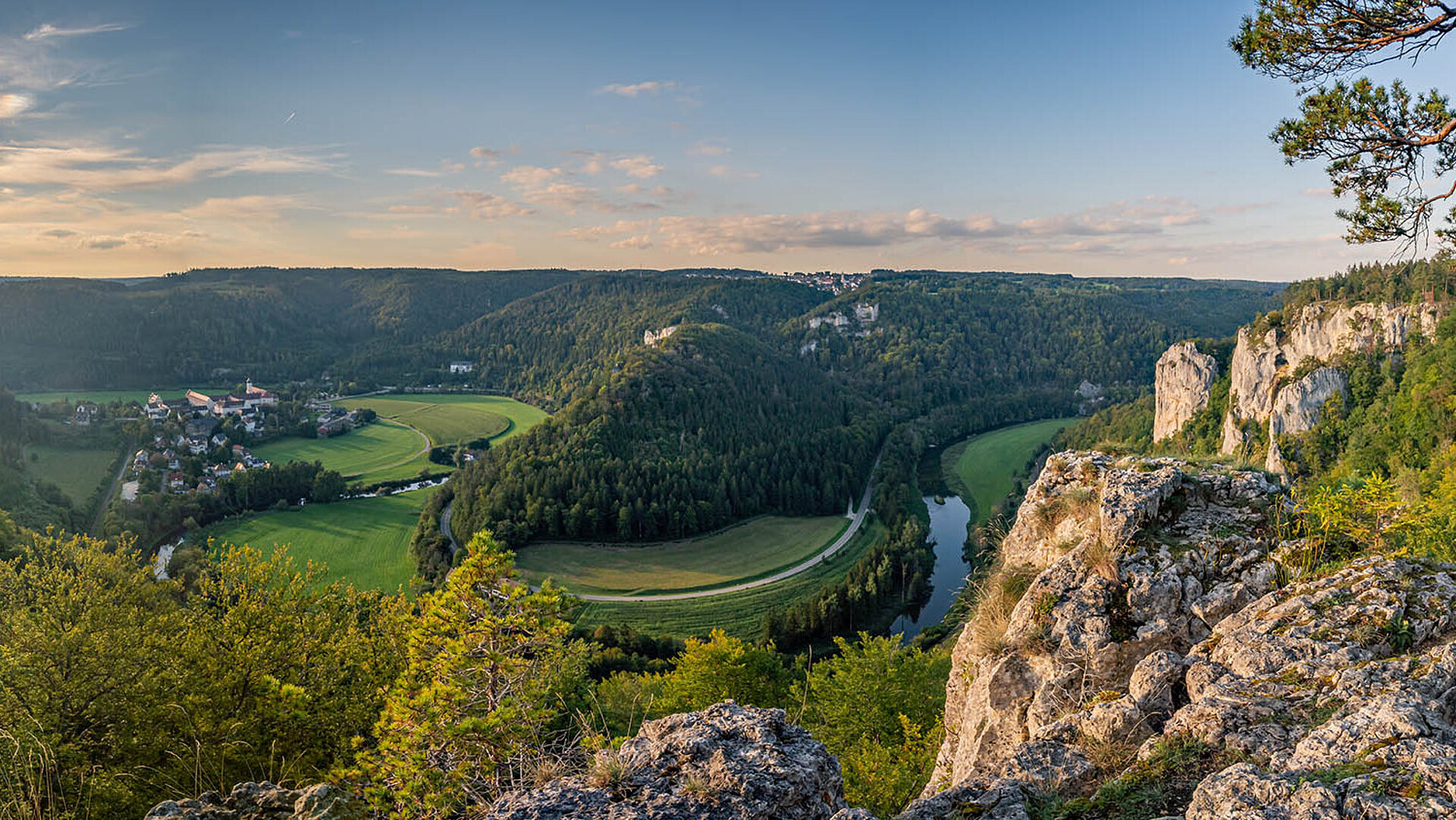 © mindscapephotos - AdobeStock.com Panorama über das Donautal mit Fluss, grünen Wiesen und steilen Felsen