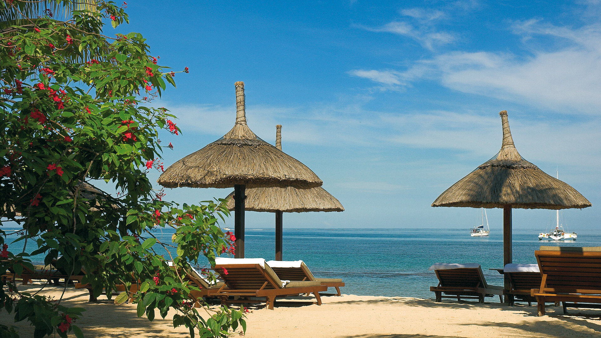 Strand mit Liegen Sonnenliegen unter Strohschirmen mit Meerblick im Maritim Hotel Mauritius