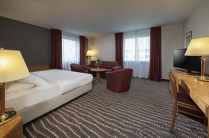 Studio Modernes Studiozimmer im Maritim Hotel Magdeburg mit gemütlicher Sitzecke und Doppelbett für einen entspannten Aufenthalt.