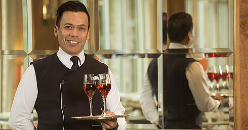 Maritim Service  Kellner mit zwei Gläsern Roséwein auf Silbertablett im Maritim Hotel Stuttgart, freundlich und professionell