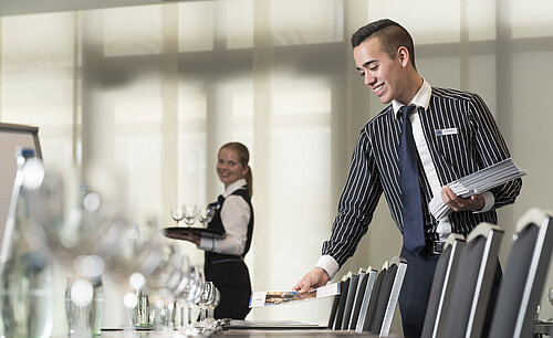 Maritim Tagungsservice Freundliches Serviceteam im Maritim Hotel Bad Homburg bereitet Tagungsraum vor.