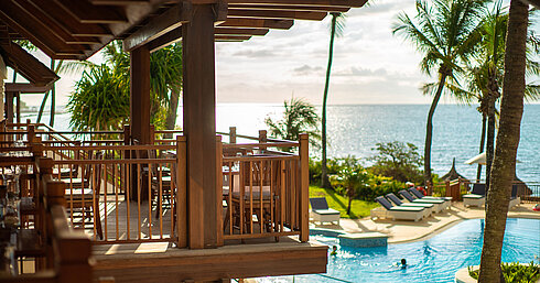 Restaurant Belle Vue Eine gemütliche Terrasse mit Restaurantmöbeln, die einen wunderschönen Blick auf den Pool und das Meer bietet
