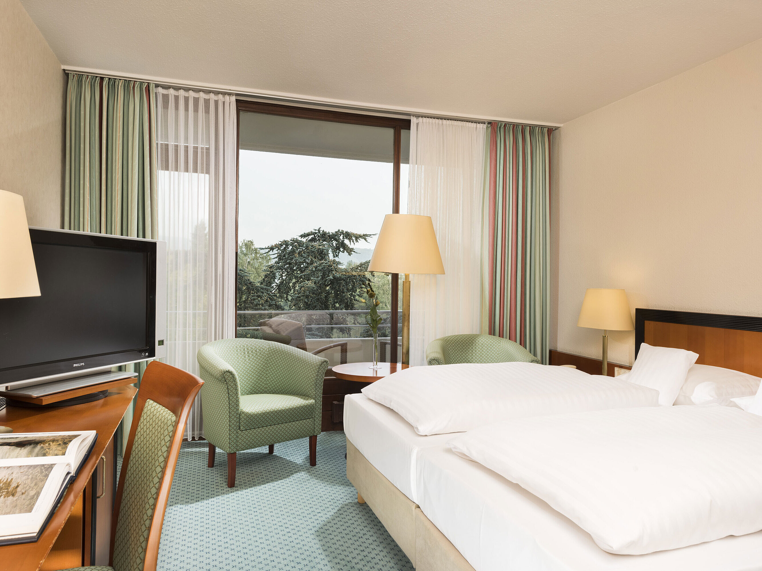 Superior Zimmer Helles Hotelzimmer im Maritim Hotel Bad Salzuflen mit Doppelbett, Sitzbereich und Zugang zum Balkon mit Ausblick