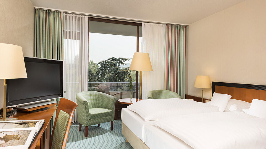 Superior Zimmer Helles Hotelzimmer im Maritim Hotel Bad Salzuflen mit Doppelbett, Sitzbereich und Zugang zum Balkon mit Ausblick