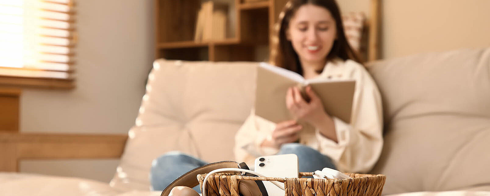 © Pixel-Shot AdobeStock.com.jpg Junge Frau entspannt auf dem Sofa mit Buch – gemütlicher Moment zu Hause mit Fokus auf Ruhe und Entspannung