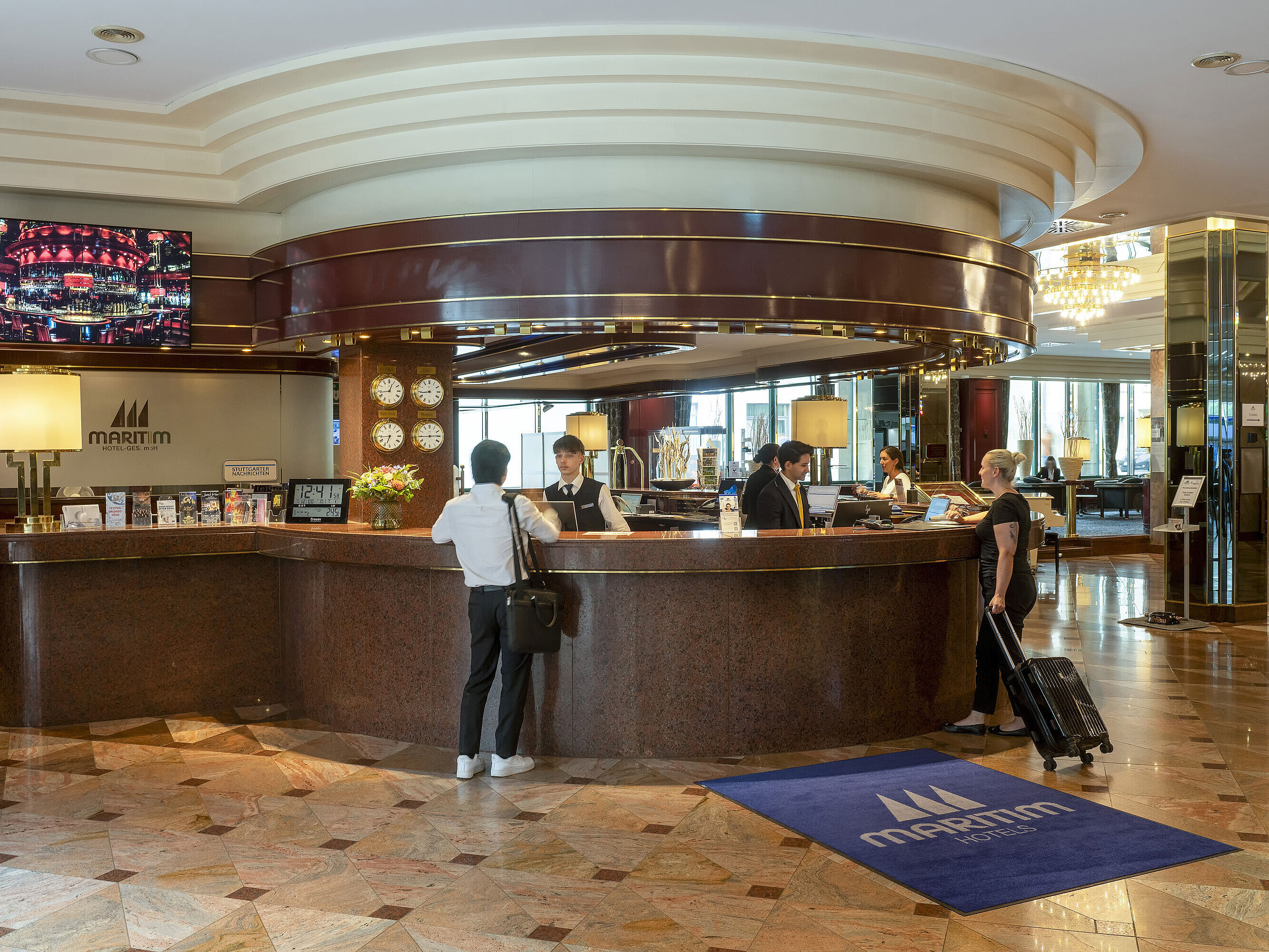 Rezeption Gäste beim Check-in an der eleganten Rezeption im Maritim Hotel Stuttgart mit stilvollem Interieur.