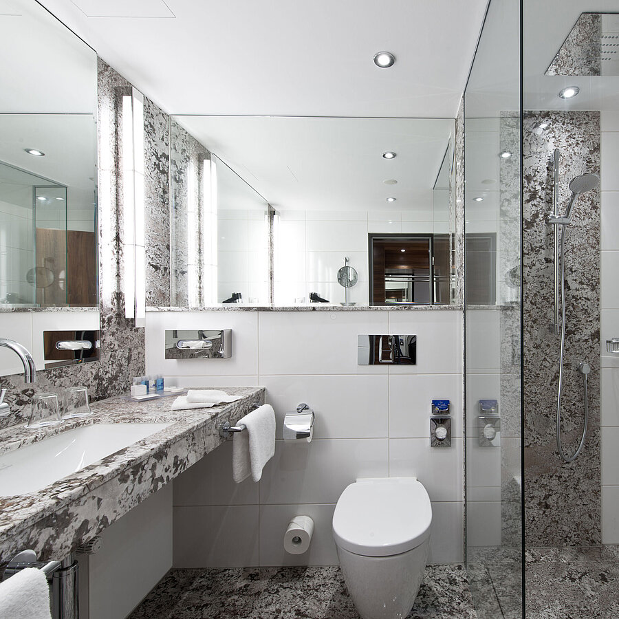 Badezimmer Modernes Badezimmer im Maritim Hotel Bad Homburg mit eleganter Regendusche und stilvollem Marmordesign.