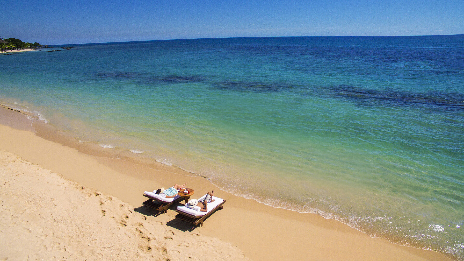 Strand Zwei Gäste entspannen auf Sonnenliegen direkt am Meer und genießen Ruhe und Meerblick