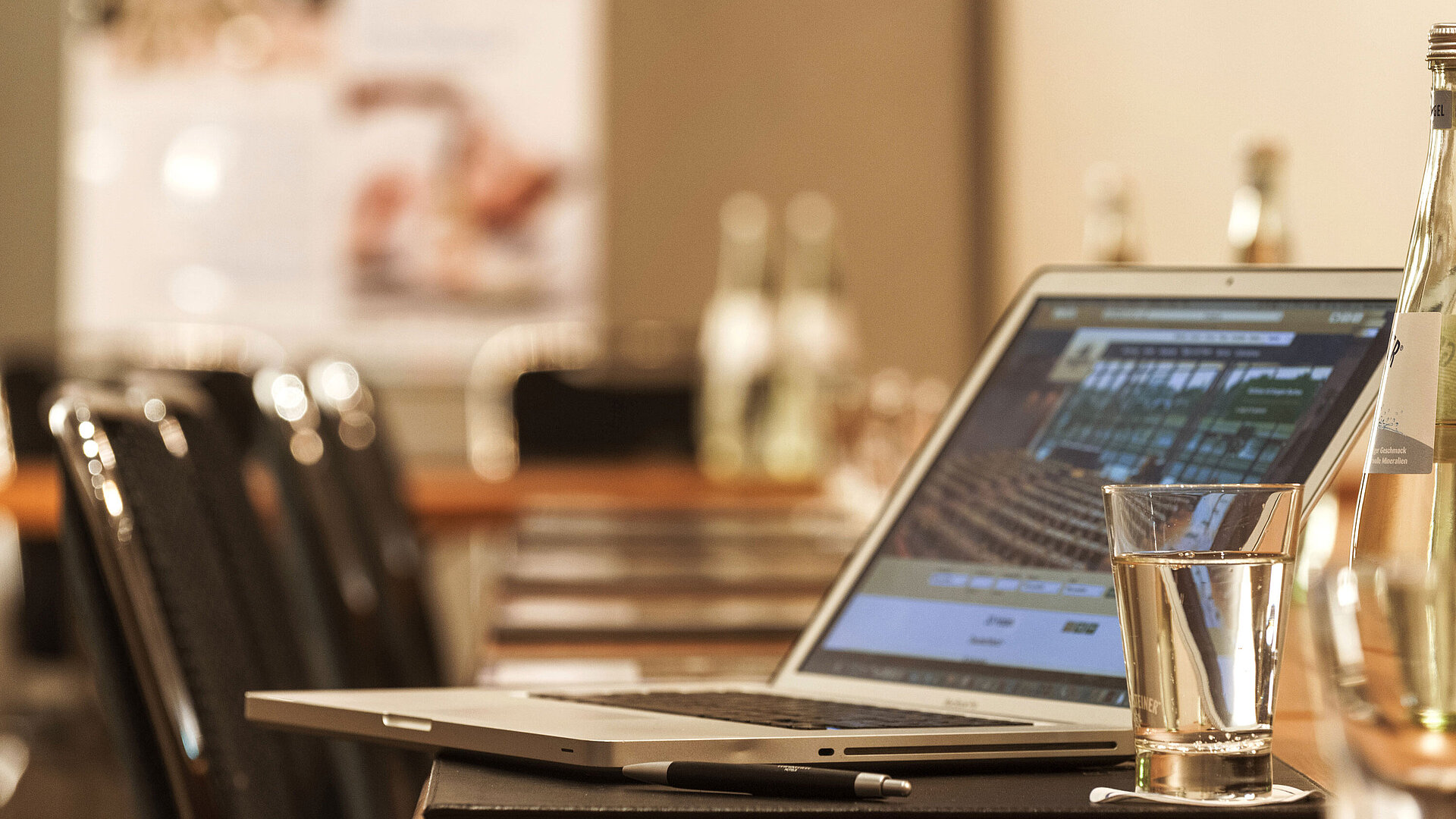 Detailansicht Tagungsraum Laptop, Stift und Wasserglas auf Tisch im Konferenzraum des Maritim Hotel München