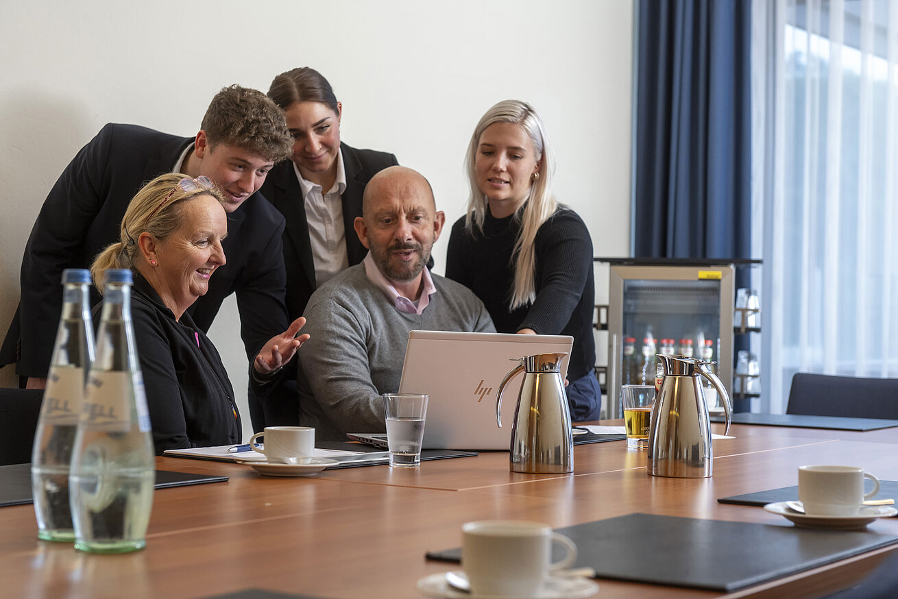 Tagung Gruppe im Konferenzraum beim Arbeiten am Laptop, freundliche Atmosphäre im Maritim Hotel Travemünde