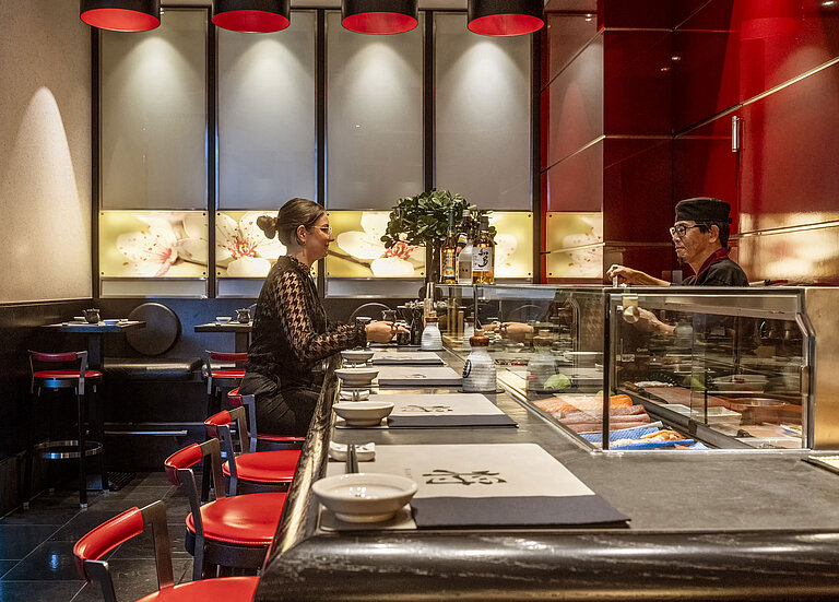 SushiSho Gast genießt frisches Sushi an der eleganten Sushi-Bar "SushiSho" im Maritim Hotel Düsseldorf mit authentischer Atmosphäre.
