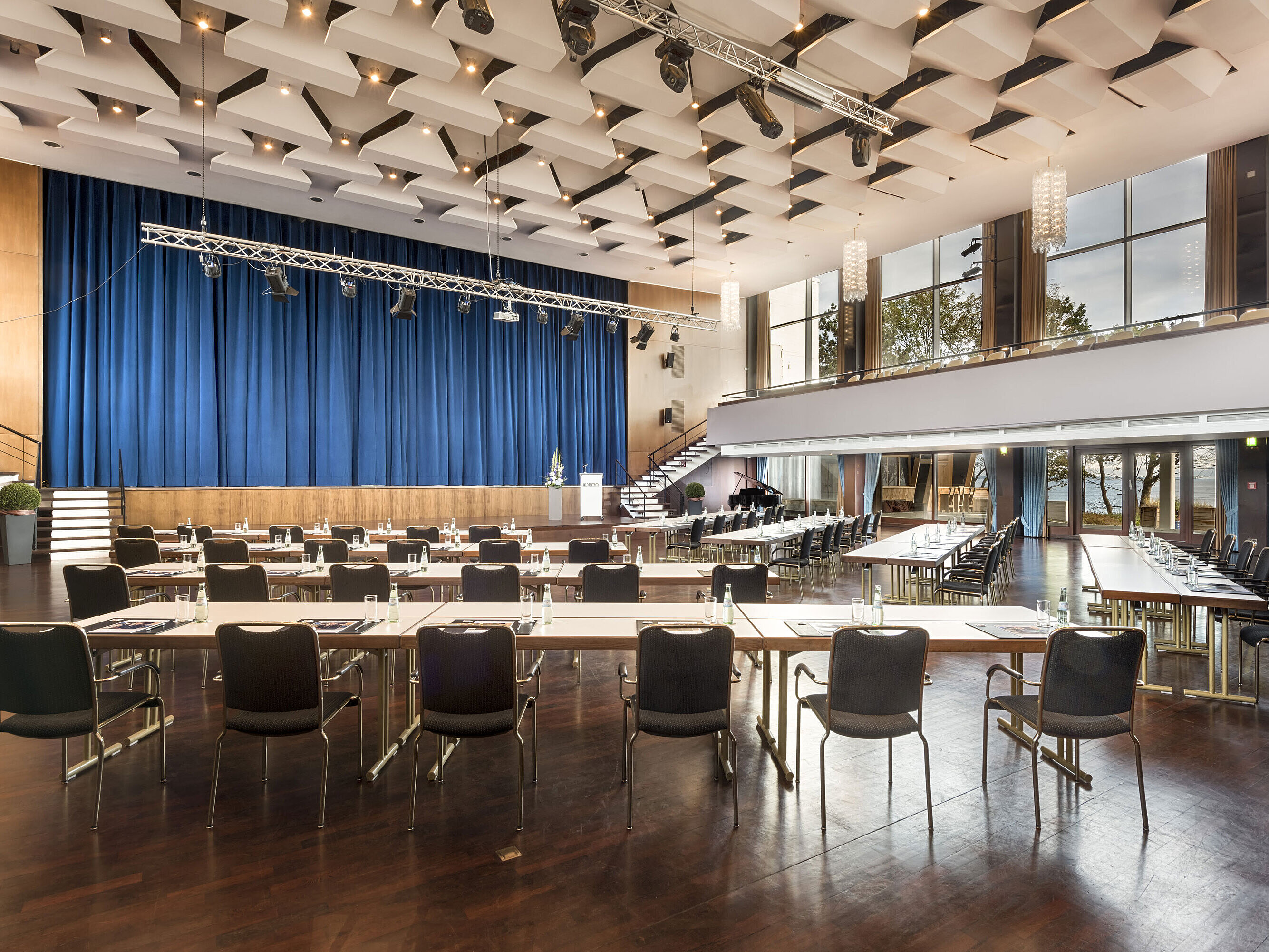 Saal Maritim Großer Saal „Maritim“ im Maritim Seehotel Timmendorfer Strand mit Bühne, blauen Vorhängen und Bestuhlung für Tagungen.