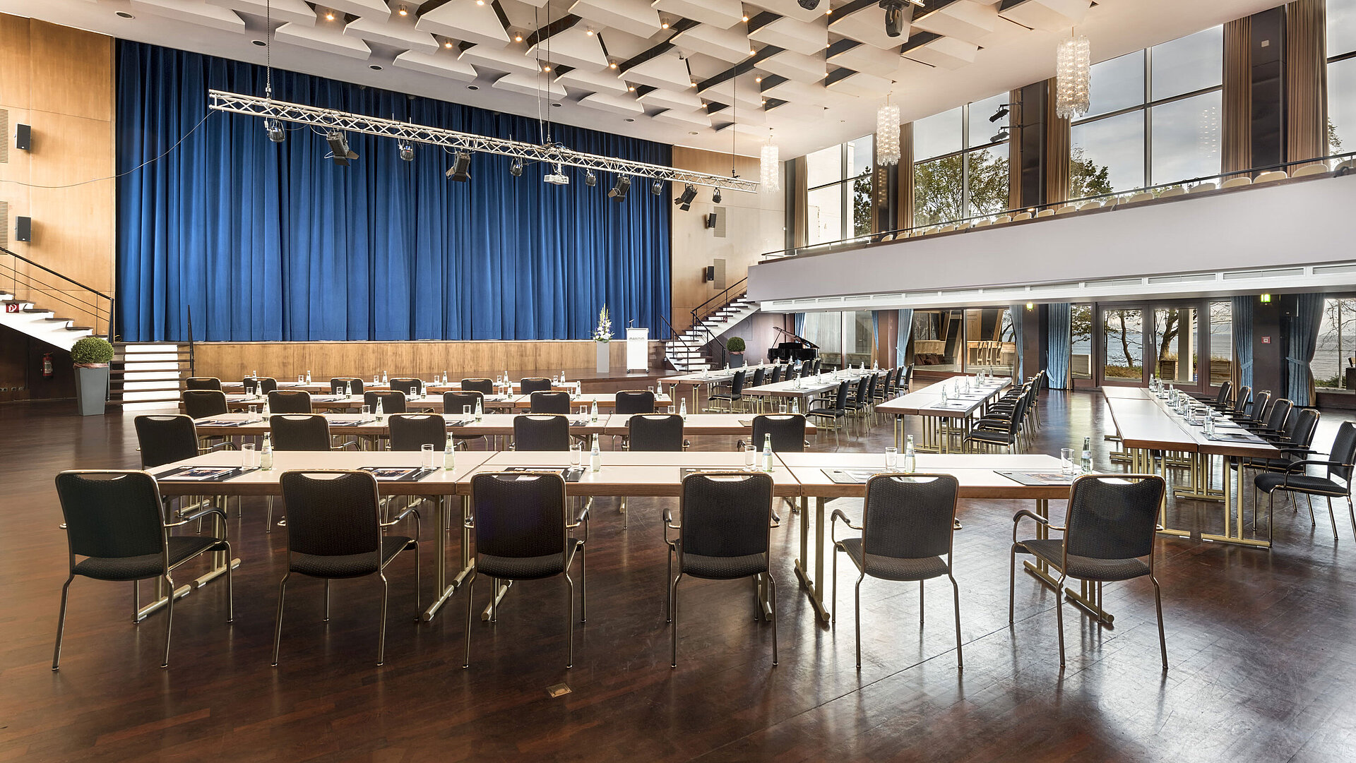 Saal Maritim Großer Saal „Maritim“ im Maritim Seehotel Timmendorfer Strand mit Bühne, blauen Vorhängen und Bestuhlung für Tagungen.