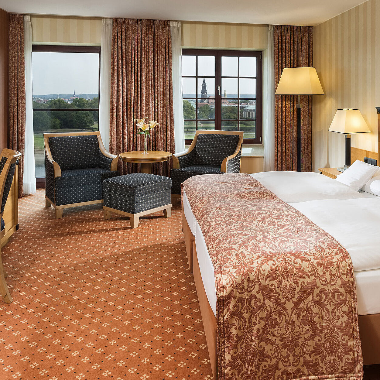 Superior Zimmer Superior Zimmer im Maritim Hotel Dresden mit elegantem Doppelbett, Schreibtisch und Sitzbereich sowie Blick auf die Stadt.