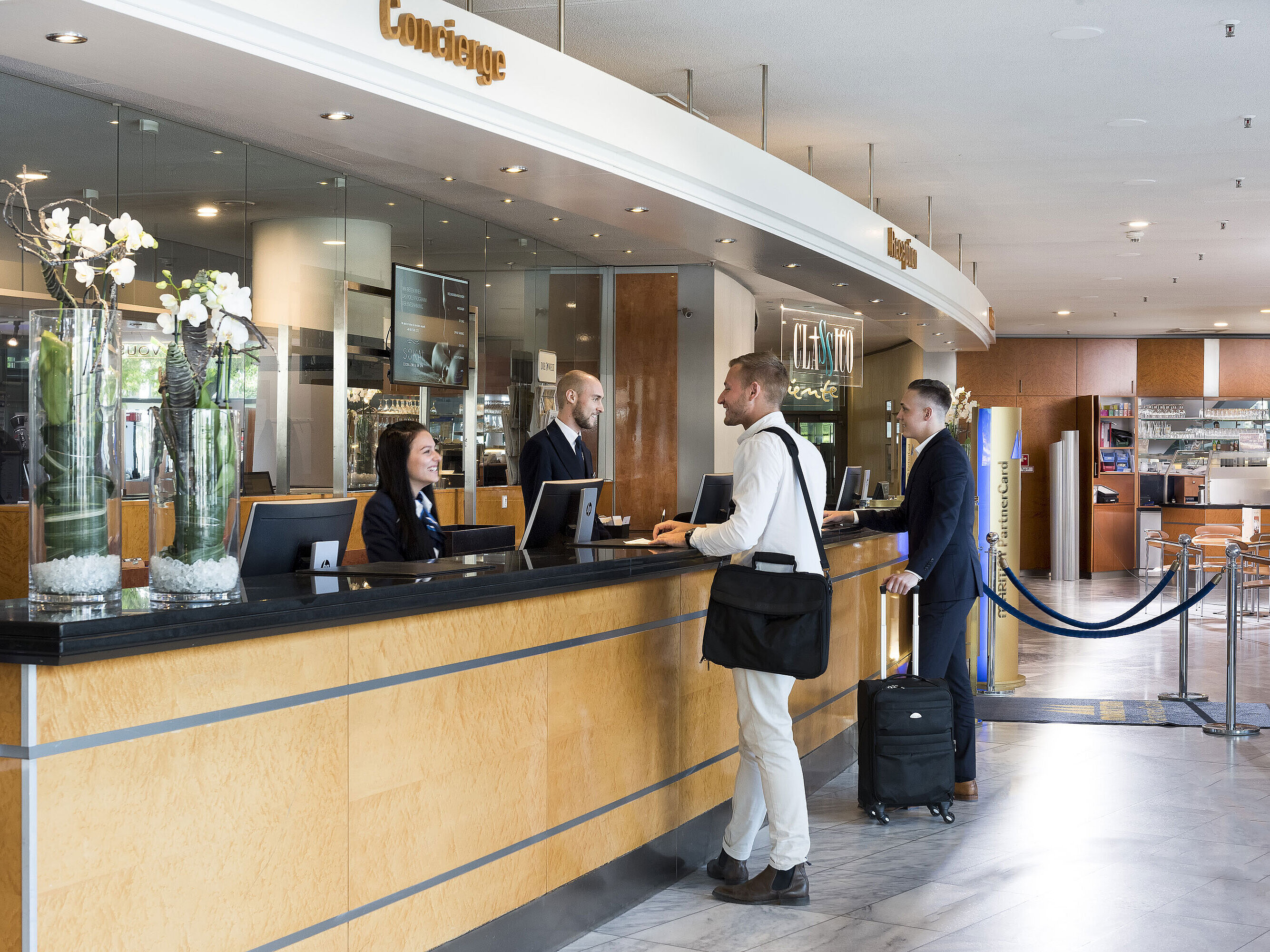 Rezeption Freundlicher Empfang an der Rezeption des Maritim Hotel Frankfurt mit Gästen und Mitarbeitern in moderner Lobby.