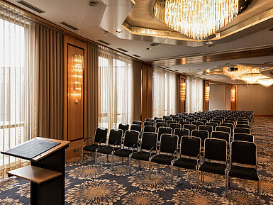 Salon Hannover/Nürnberg Großer Konferenzsaal mit Reihenbestuhlung, Rednerpult und Kronleuchtern im Maritim Hotel Ulm.