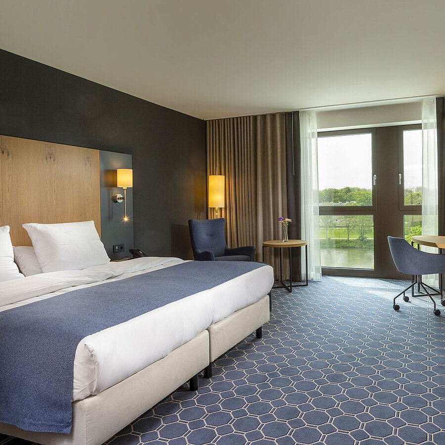 Superior Zimmer Geräumiges Doppelzimmer im Maritim Hotel Ingolstadt mit Bett, Schreibtisch und Blick auf den Fluss.