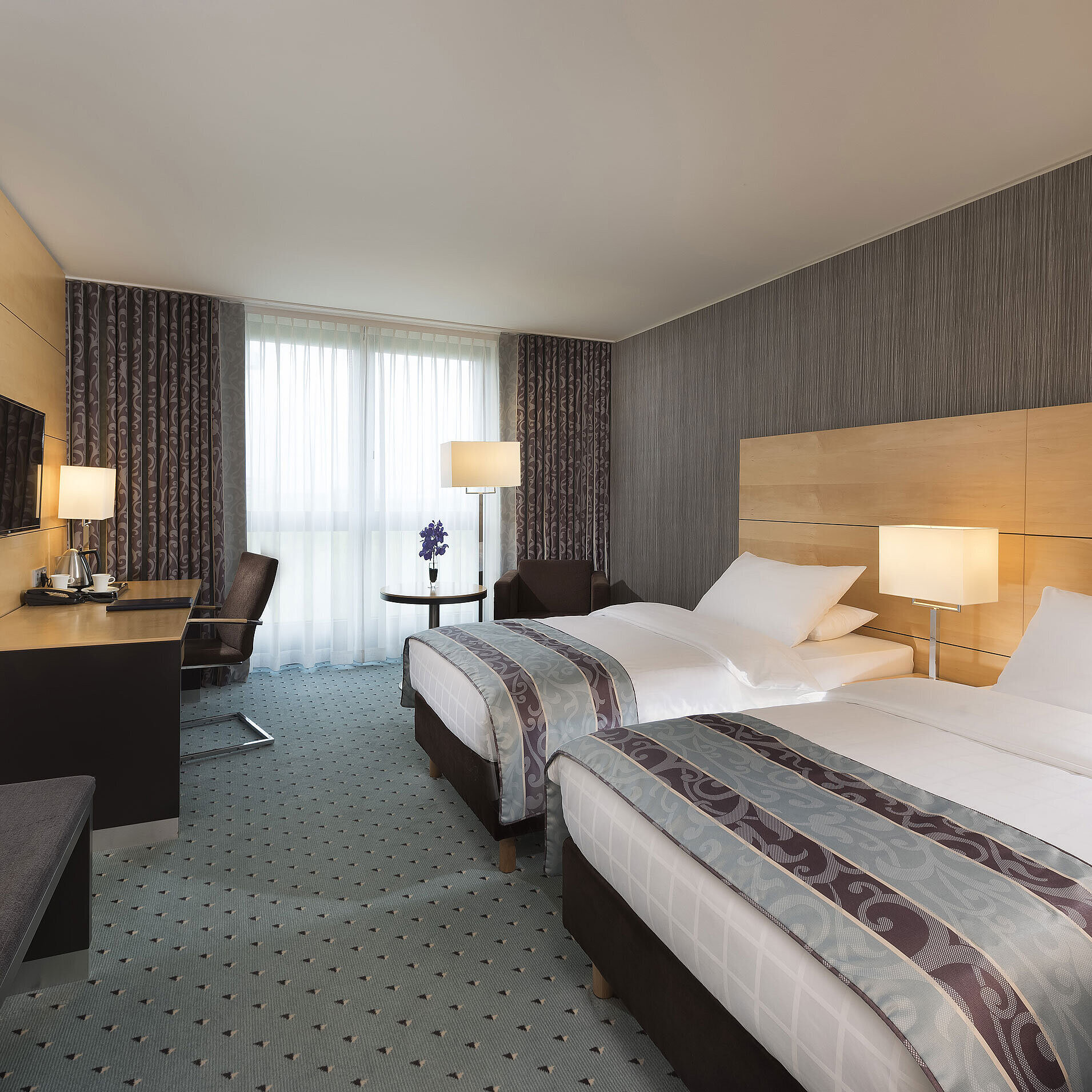 Classic Zimmer Modernes Classic Twin Zimmer im Maritim Hotel Düsseldorf mit zwei Einzelbetten, Schreibtisch und bodentiefem Fenster.