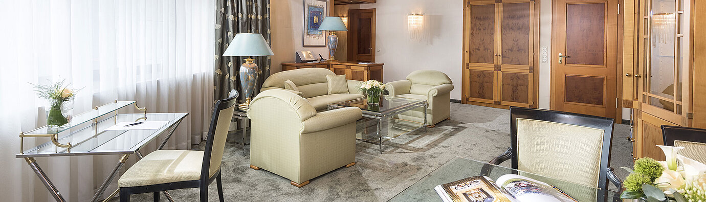 Luxus Suite Großzügige Suite mit eleganter Einrichtung, Glastisch und gemütlicher Sitzgruppe im Maritim Hotel Magdeburg