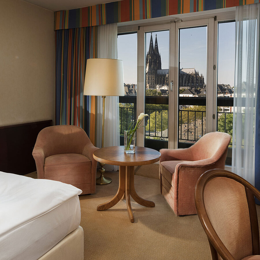 Superior Zimmer  Superior-Zimmer im Maritim Hotel Köln mit Sitzbereich, komfortablem Bett und Blick auf den Kölner Dom.