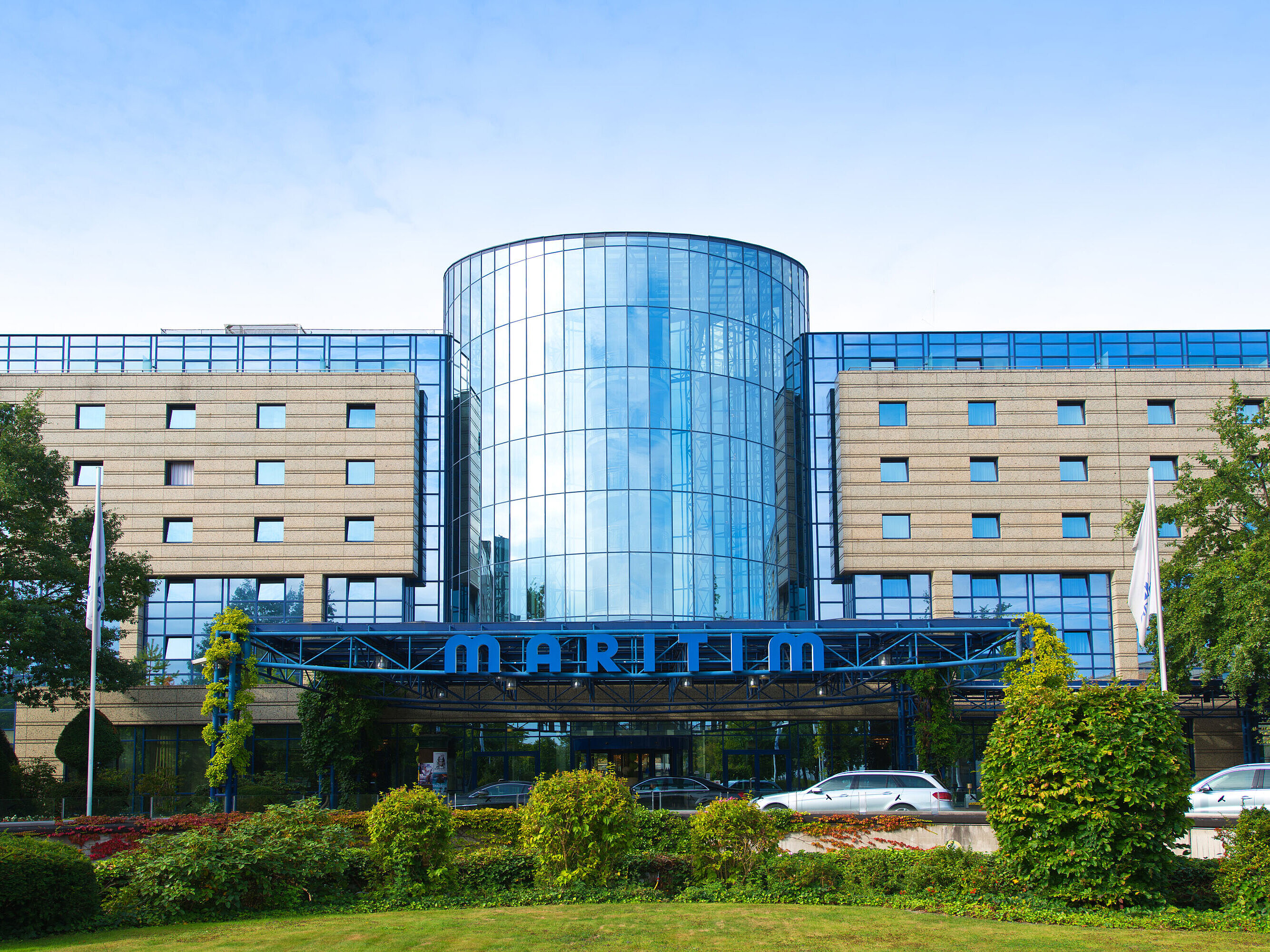 Außenansicht Außenansicht des Maritim Hotels Bonn mit moderner Glasfassade und gepflegter Gartenanlage im Vordergrund.