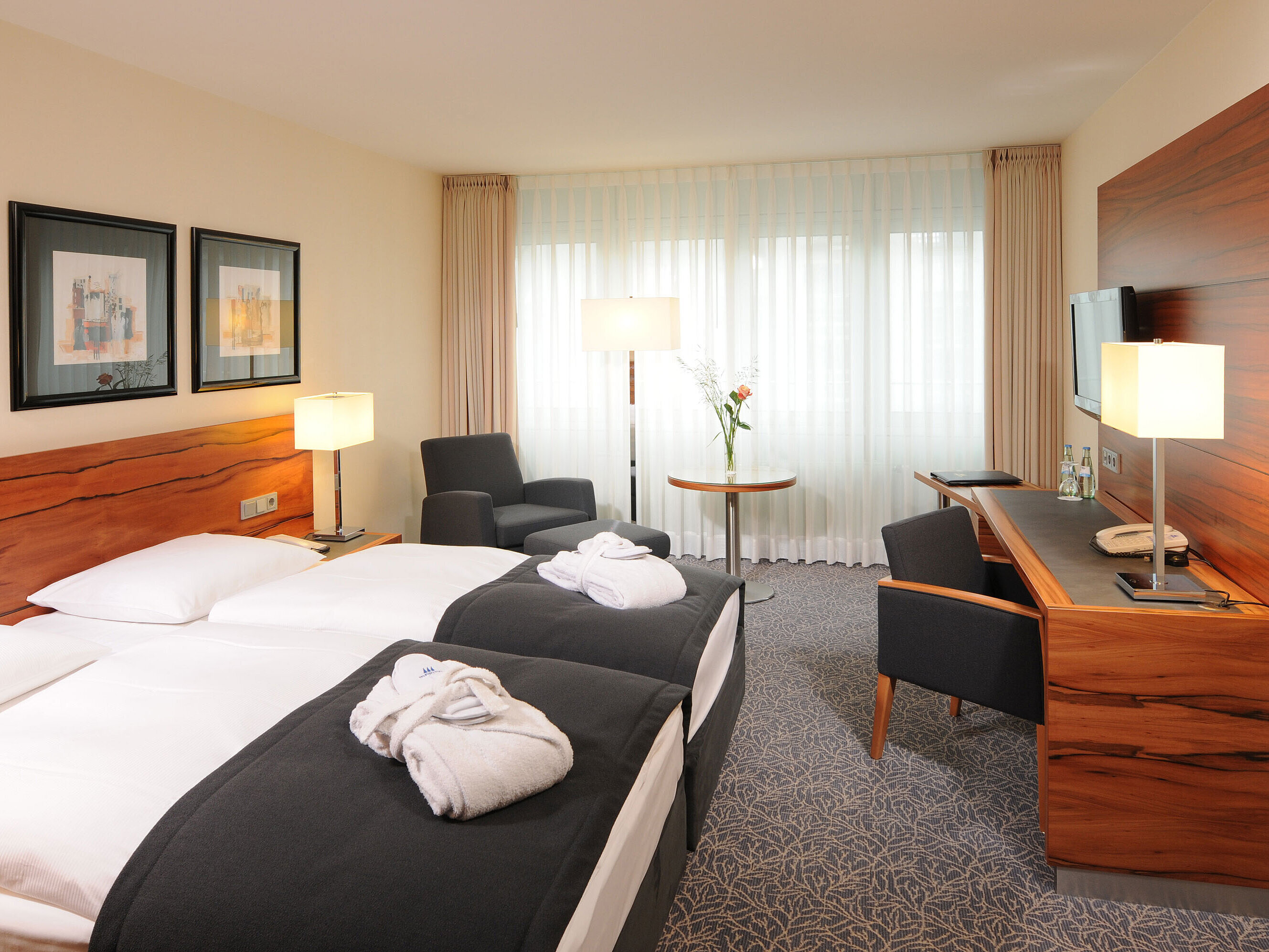 Superior Zimmer Helles Doppelzimmer mit Schreibtisch, Sesseln und Bademänteln im Maritim Hotel München