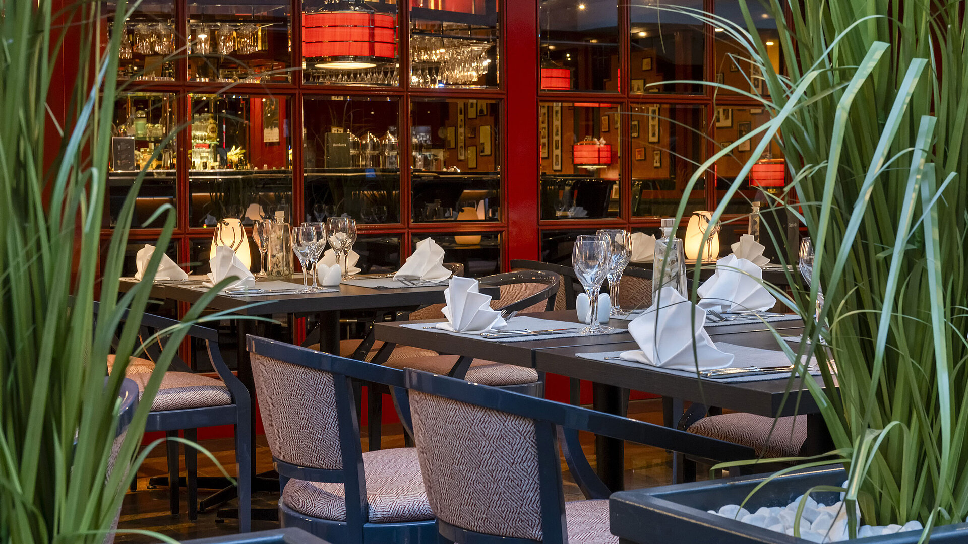 Bistro der Pianobar Stilvoll gedecktes Bistro im Maritim Hotel Magdeburg mit freundlicher Mitarbeiterin, die Tische vorbereitet.