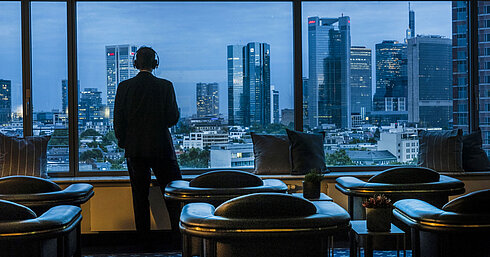 Sky-Lounge Gast genießt den Panoramablick auf die Skyline von Frankfurt in der Sky Lounge des Maritim Hotel Frankfurt.