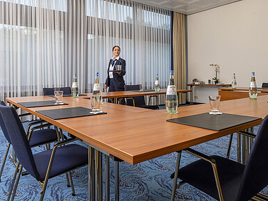 Salon Kiel Tagungsraum mit U-Bestuhlung und freundlicher Maritim-Mitarbeiterin im Maritim Hotel Travemünde