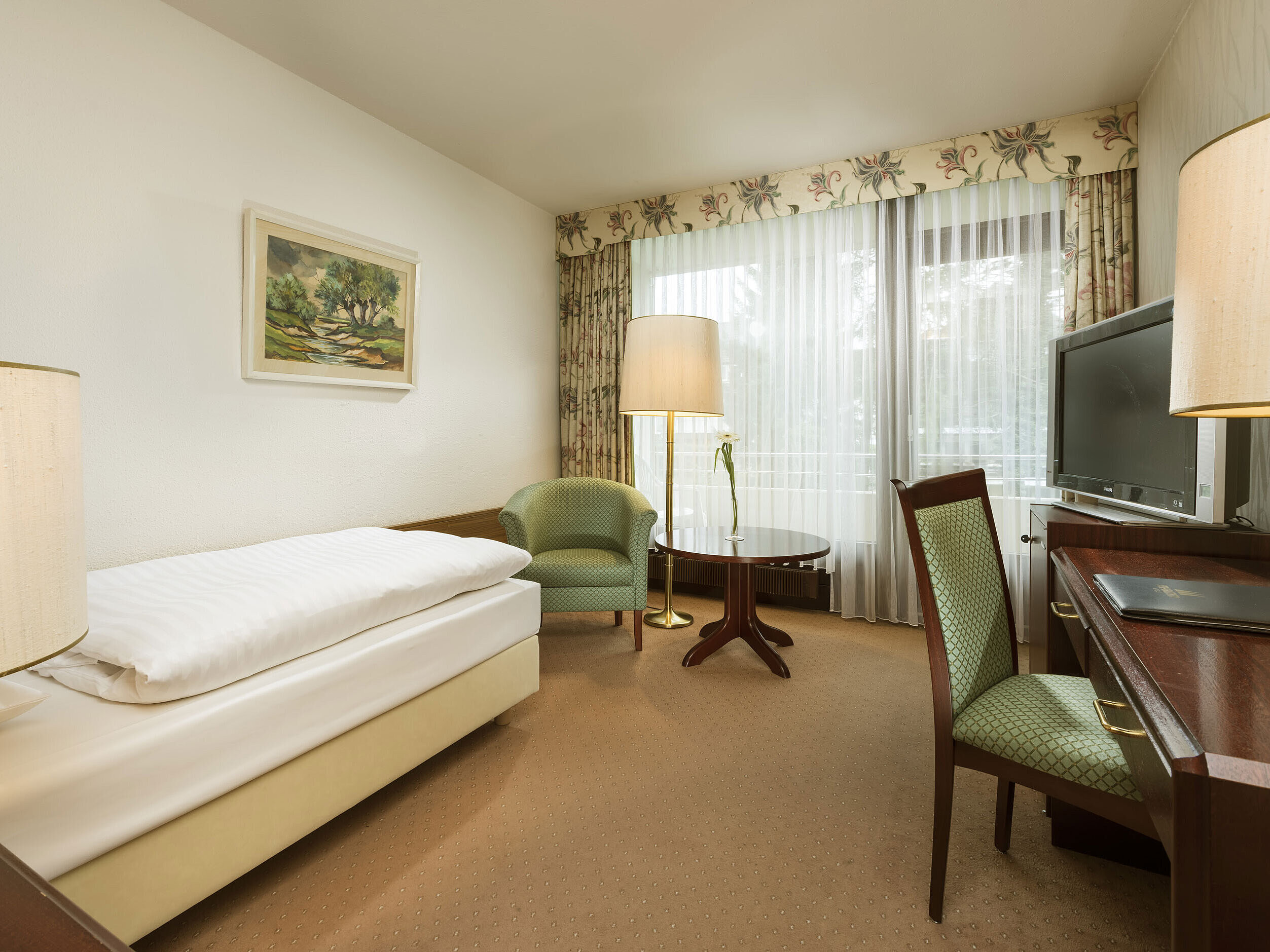 Classic Zimmer Einzelzimmer mit Schreibtisch, Sessel und Balkonzugang im Maritim Hotel Bad Salzuflen