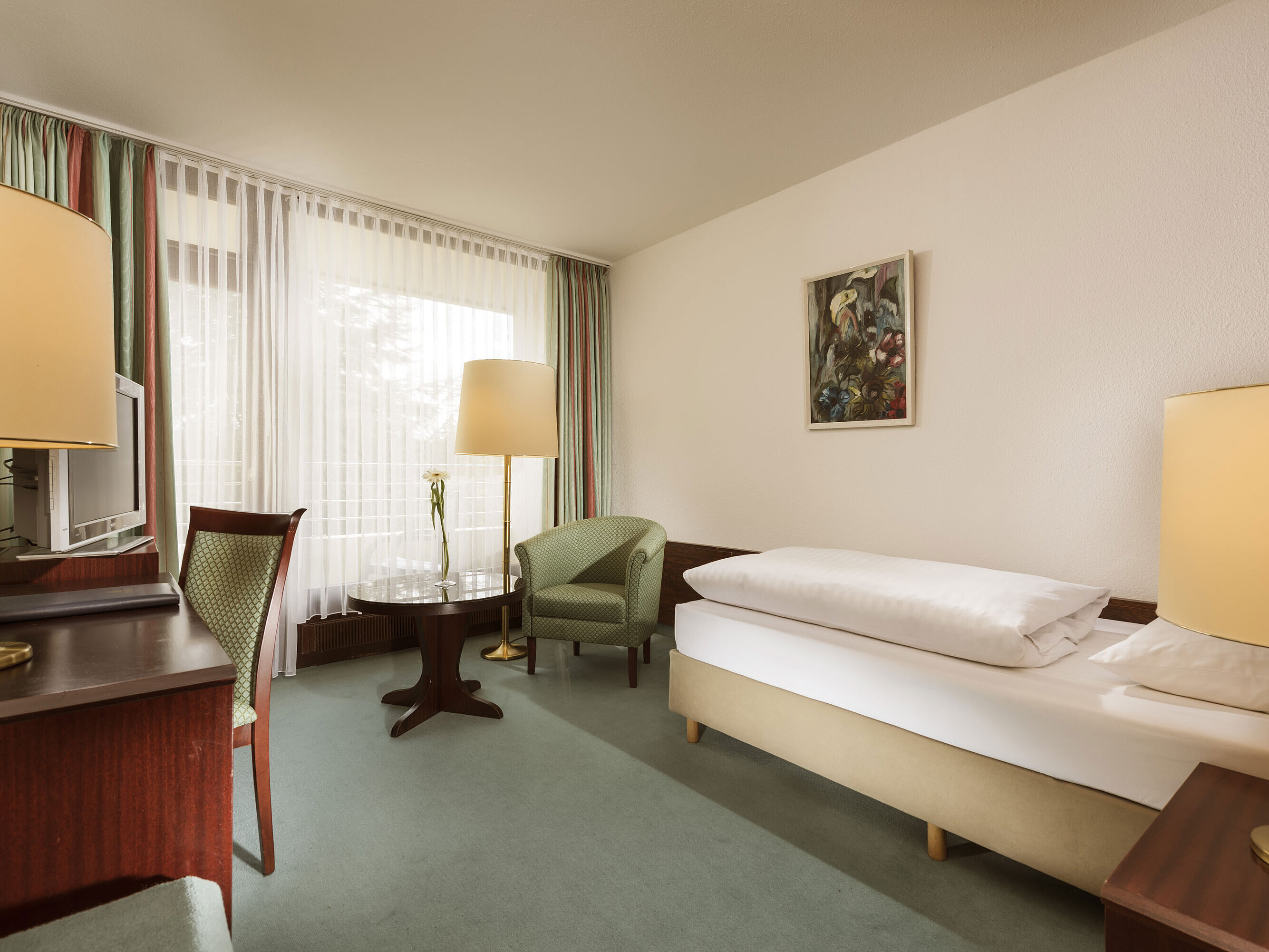 Comfort Zimmer Freundliches Einzelzimmer mit Sessel, Schreibtisch und großem Fenster im Maritim Hotel Bad Salzuflen