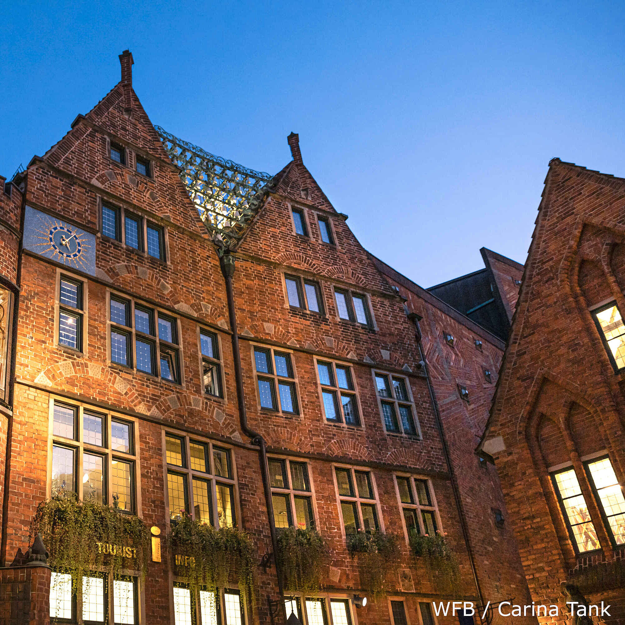 Bremen bei Nacht Beleuchtete, historische Gebäude mit Uhr und Touristeninformation in Bremen bei Nacht