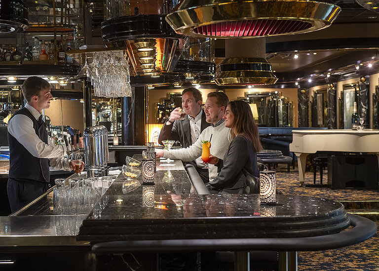 Piano Bar Gäste genießen Cocktails an der Pianobar im Maritim Hotel Köln, während der Barkeeper sie bedient.