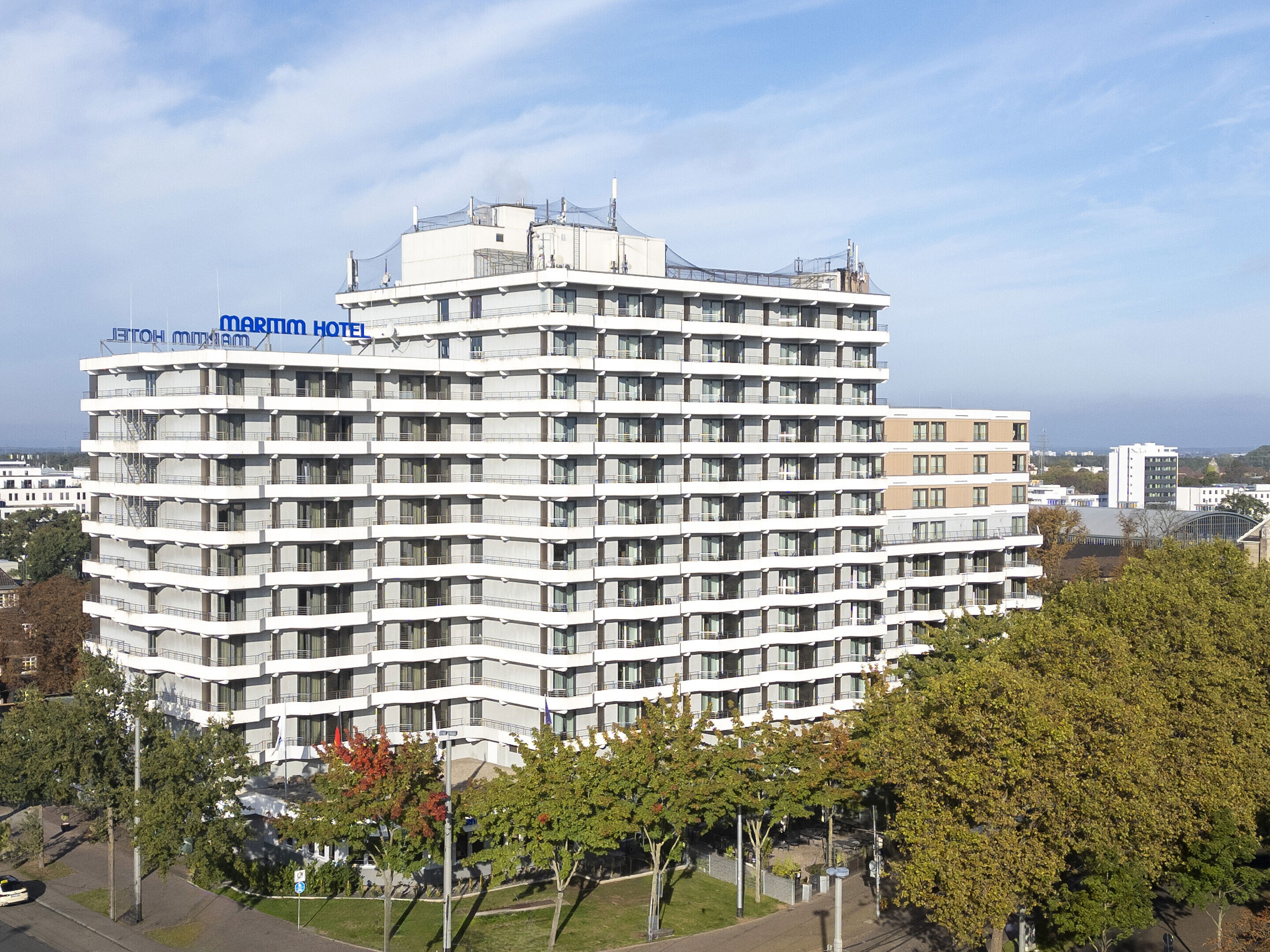 Außenansicht Außenansicht des Maritim Hotel Darmstadt mit moderner Architektur und grünen Bäumen im Vordergrund.