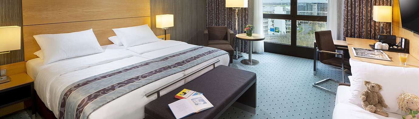Superior Familienzimmer Geräumiges Superior Familienzimmer im Maritim Hotel Düsseldorf mit großem Bett, Zusatzbett und Blick auf die Stadt.