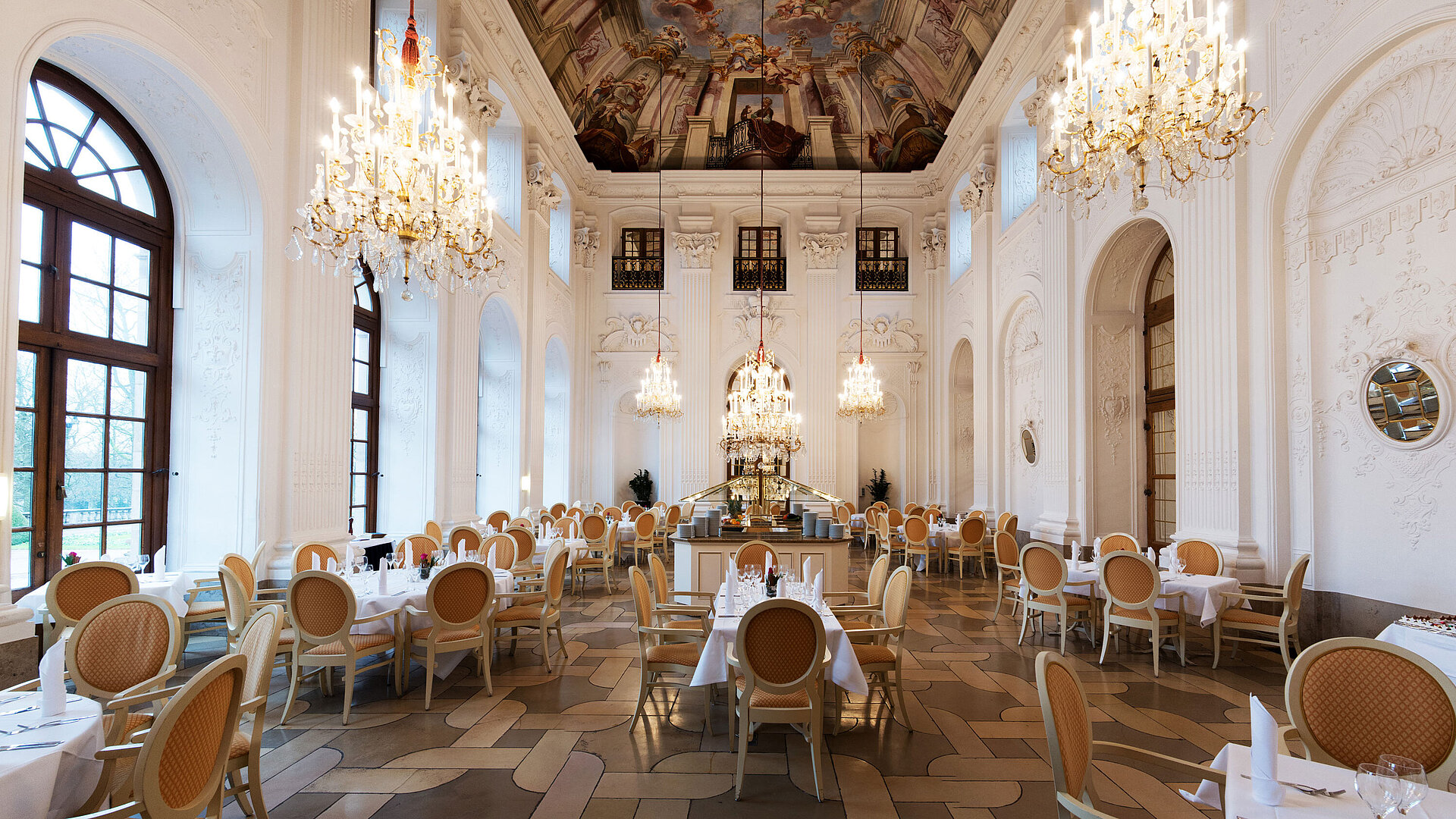 Restaurant "Apollo Saal" Eleganter Apollo Saal im Maritim Hotel Fulda mit Kronleuchtern, Freskendecke und stilvoll gedeckten Tischen.