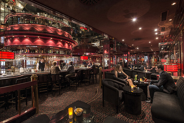 Pianobar Gäste genießen Drinks in der atmosphärisch beleuchteten roten Hotelbar im Maritim Hotel Stuttgart