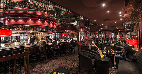 Pianobar Gäste genießen Drinks in der atmosphärisch beleuchteten roten Hotelbar im Maritim Hotel Stuttgart