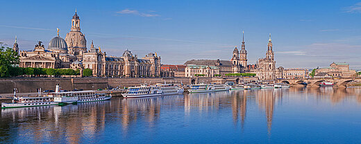 © majonit - AdobeStock.com Blick auf die Dresdner Altstadt mit Frauenkirche und Elbe, Schiffe spiegeln sich im Wasser