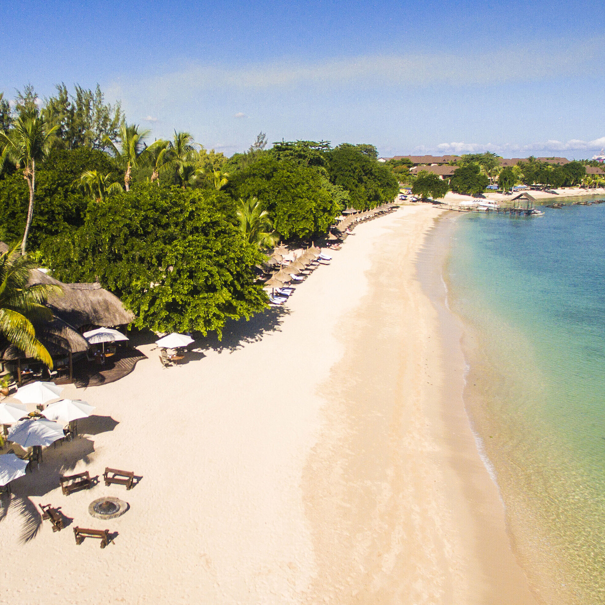Strand Der weiße Sandstrand im Maritim Resort & Spa Mauritius lädt zum Entspannen unter Palmen und Sonnenschirmen ein
