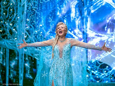 © Disney Foto Johann Persson Darstellerin als Eiskönigin in funkelndem blauen Kostüm auf eisiger Bühnenkulisse