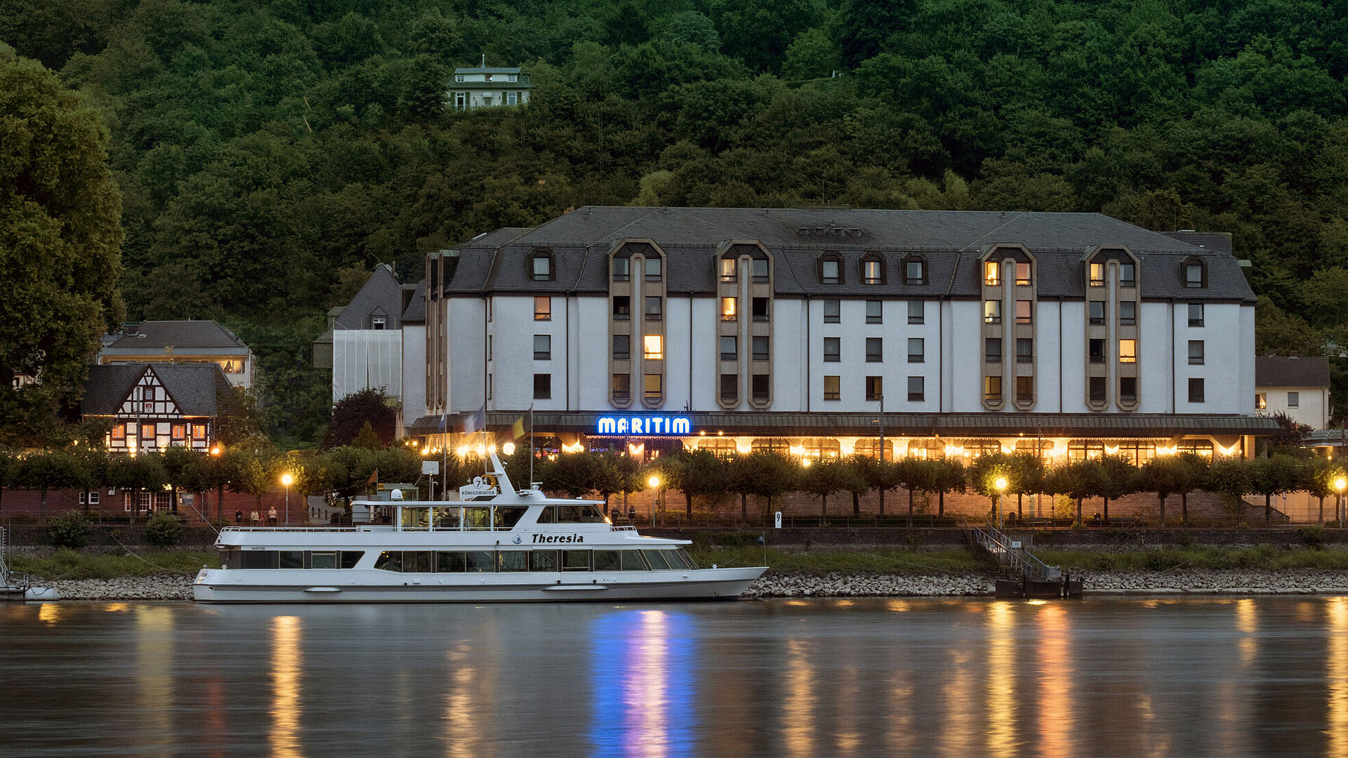 Außenansicht bei Nacht Das Maritim Hotel Königswinter bei Nacht mit stimmungsvoller Beleuchtung und Blick auf den Rhein.