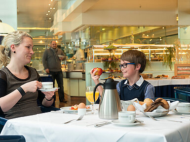Frühstück im Hotel Eine Mutter und ihr Sohn genießen ein entspanntes Frühstück im Maritim Hotel Magdeburg,mit Blick auf das Buffet im Hintergrund