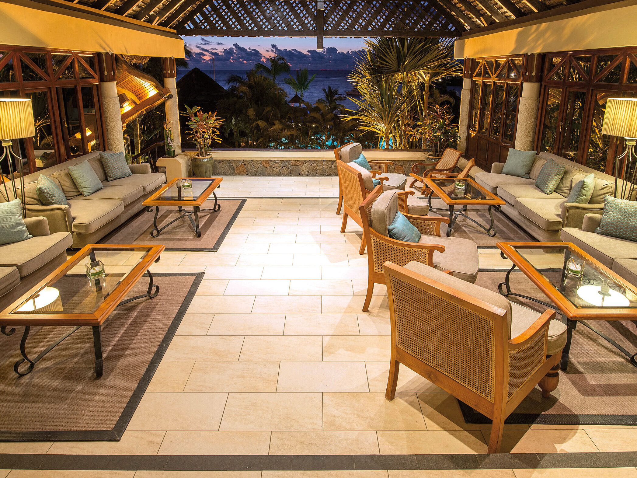 Lobby Elegante Hotel-Lounge mit Sofas, Sesseln und Meerblick bei stimmungsvoller Abendbeleuchtung