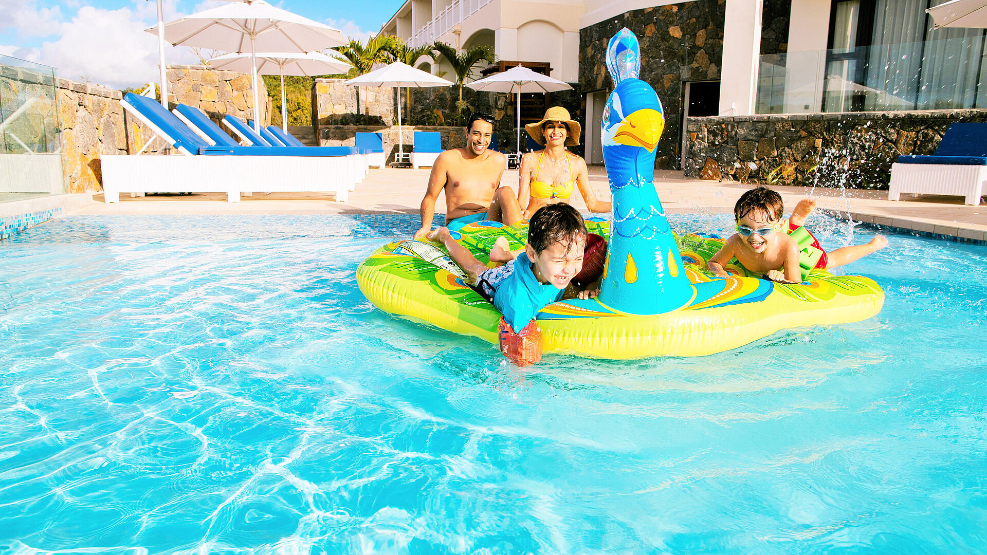 Pool Kinder und Eltern haben Spaß im Hotelpool mit aufblasbarem Spielzeug