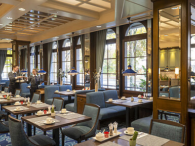 Restaurant "Landgraf" Elegantes Restaurant im Maritim Hotel Darmstadt mit gedeckten Tischen, großen Fenstern und Servicemitarbeitern im Gespräch.
