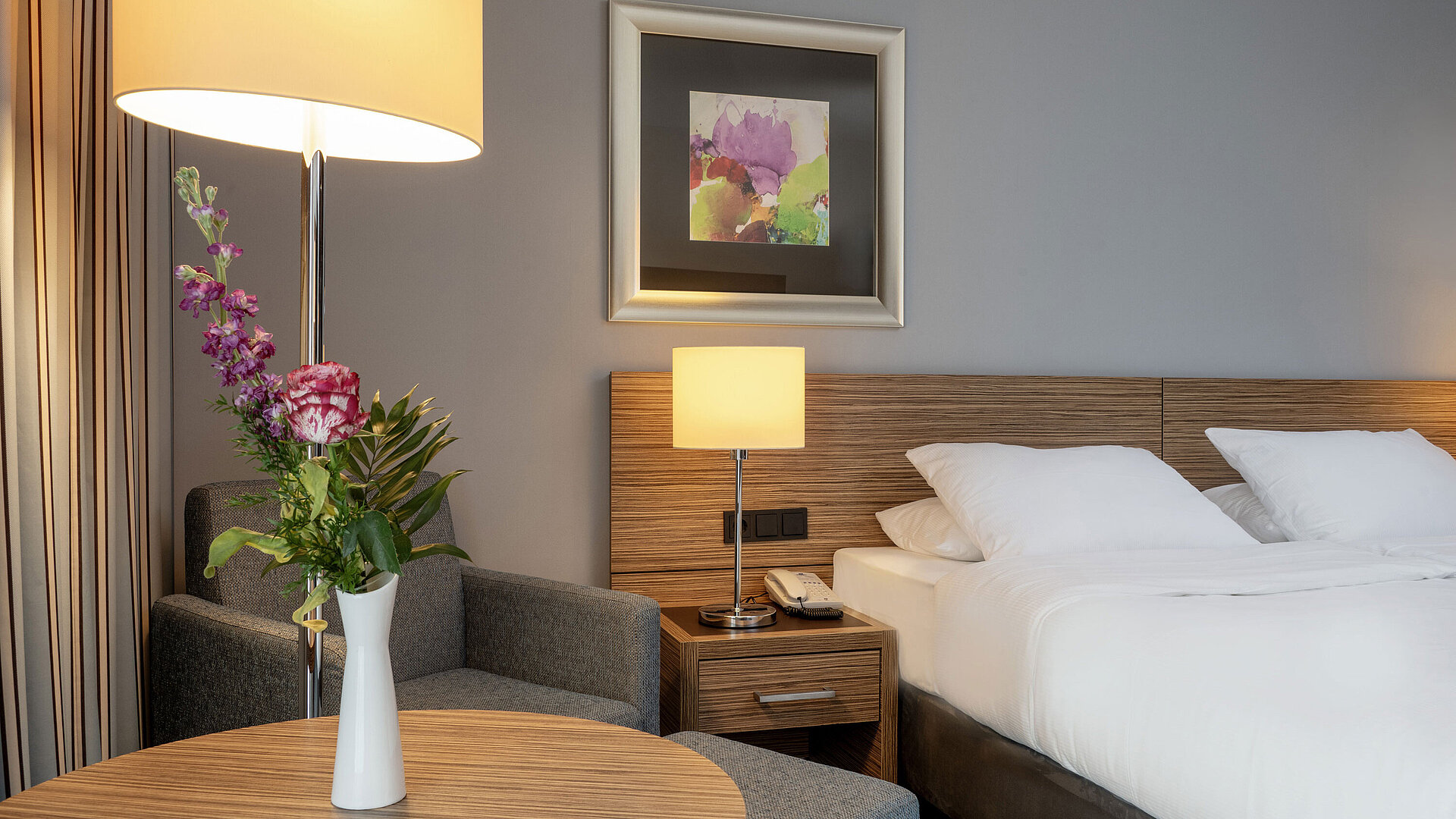 Zimmerdetails Gemütliche Sitzecke mit Blumenvase neben dem komfortablen Bett im Superior Zimmer des Maritim Hotel Darmstadt