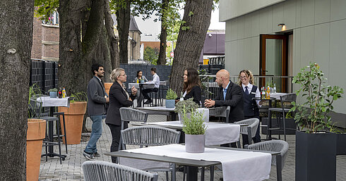 Terrasse Saal Maritim Moderne Terrasse im Maritim Hotel Darmstadt mit Gästen, die entspannen, Bäumen im Hintergrund und stilvollen grauen Möbeln.