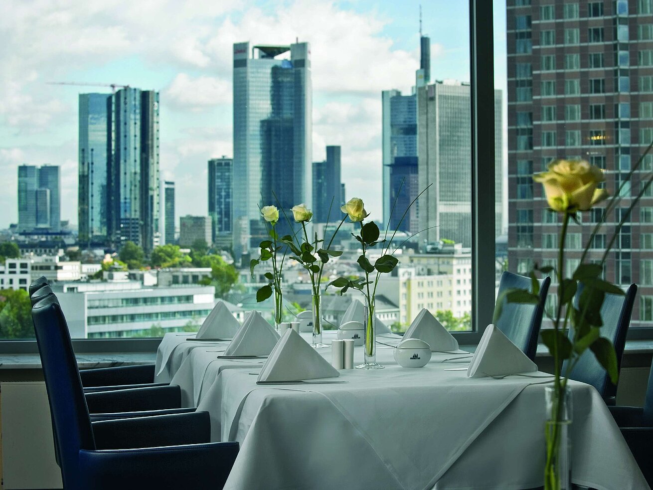 SkyLounge Eleganter Speiseraum mit Skyline-Blick und gedecktem Tisch in der SkyLounge im Maritim Hotel Frankfurt.